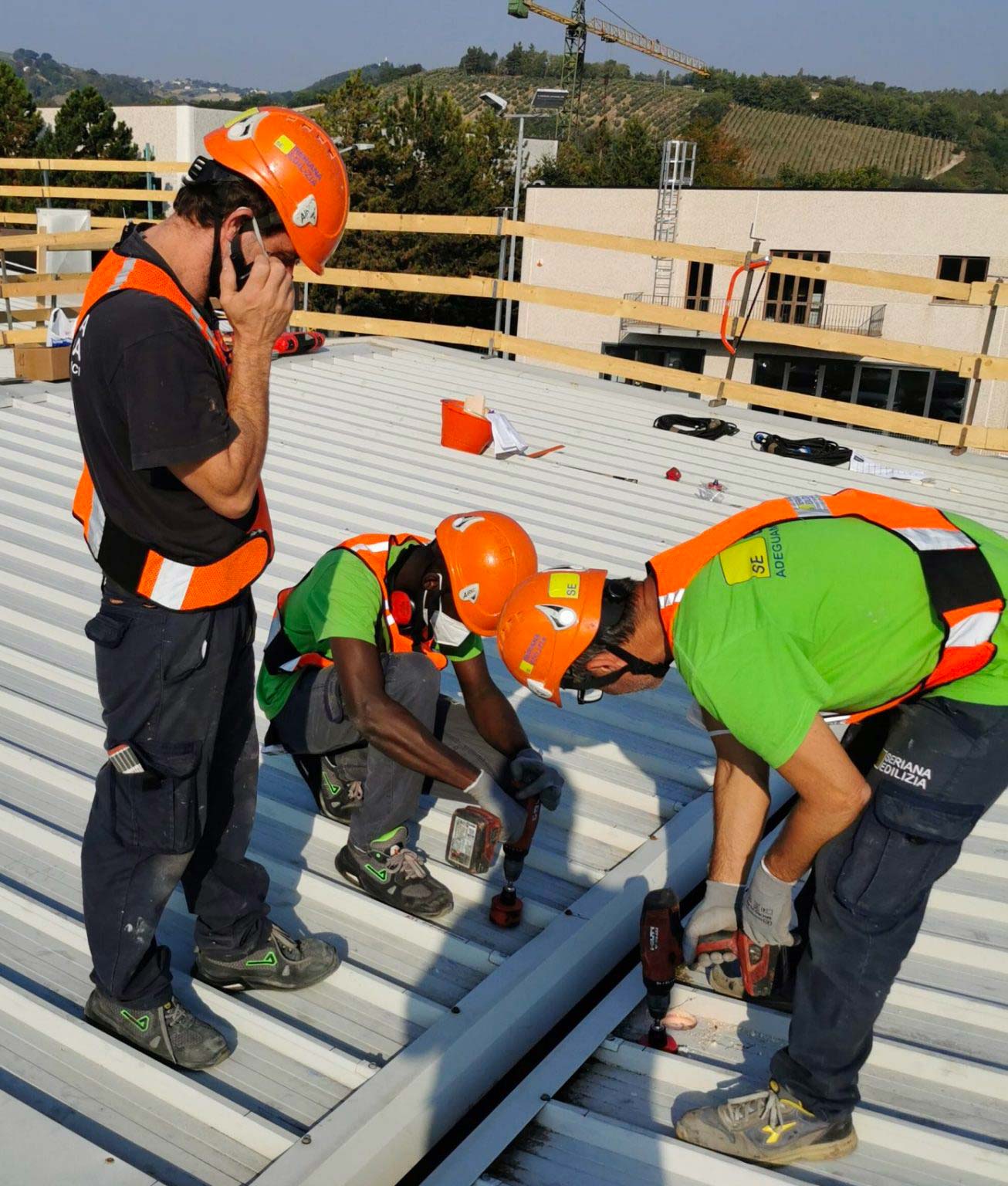 personale Seriana Edilizia all'opera sul tetto di struttura industriale 