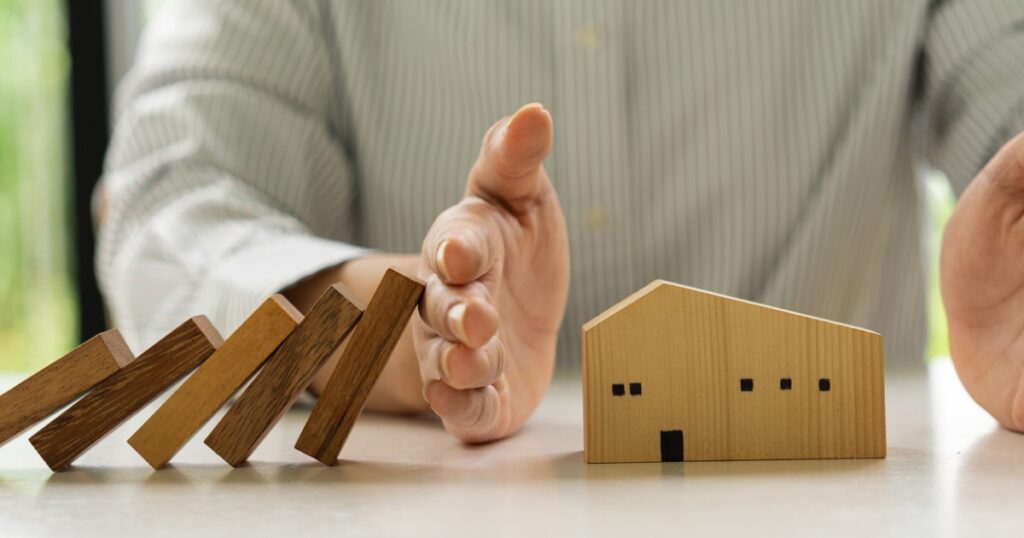 casa di legno protetta da domino che cadono